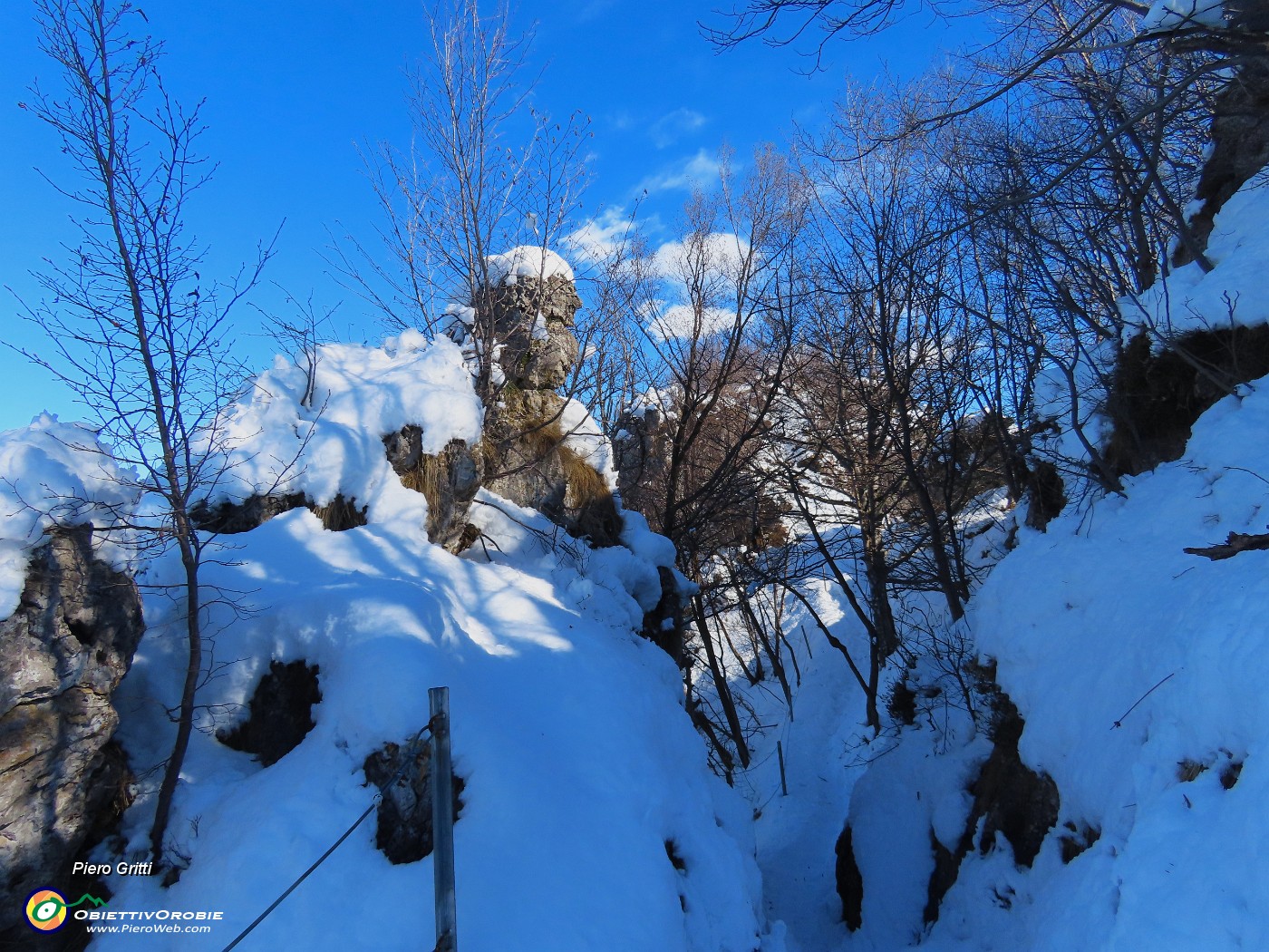 41 Il sentiero corre tra roccioni coperti di neve.JPG